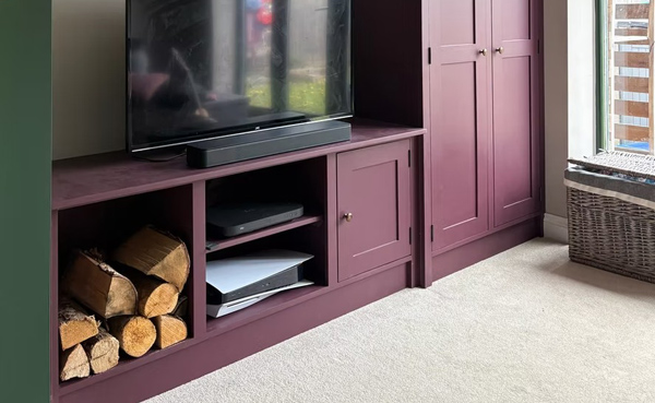 interior living room with modern television stand featuring wood storage logs and shelves for electronics and decor in stylish purple design